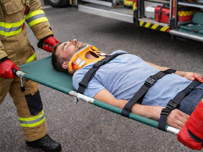 Ratownik niesie rannego na noszach